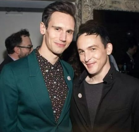 Robin and Richard is wearing green coat and black shirt with black t-shirt.